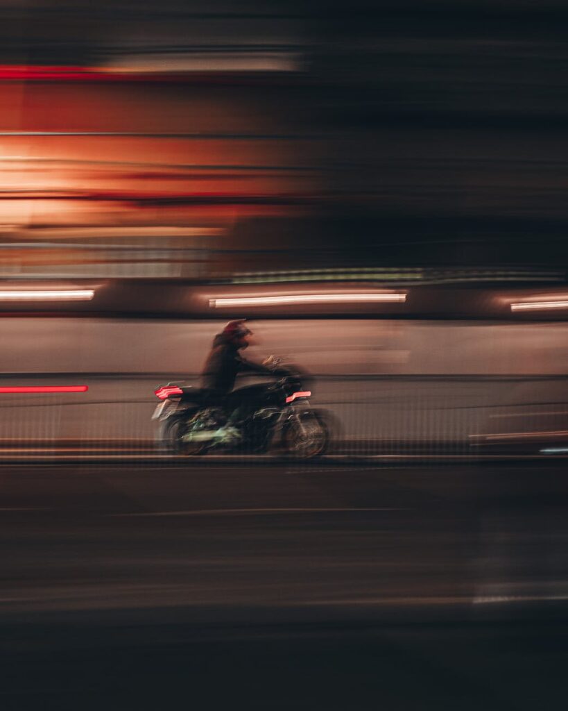 man riding motorcycle on road during night time