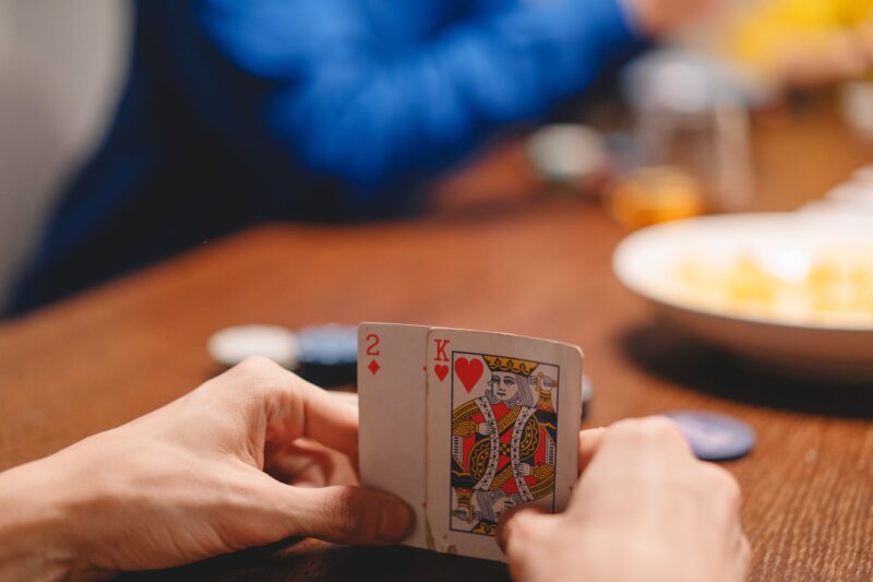 Played lottery to bankruptcy, selective focus photo of a person s hands holding playing cards