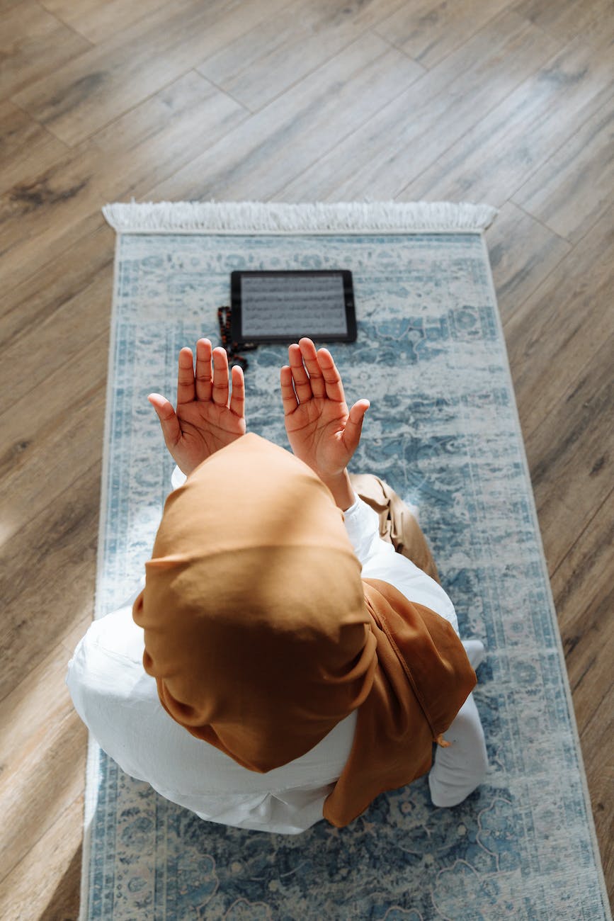 Ya Allah Mujhe, high angle shot of a person kneeling on a blue prayer rug
